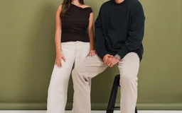 Two Rheal customers in front of a green wall