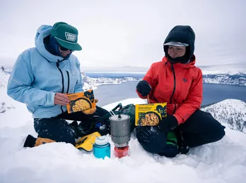 Two hikers at a snow camp in the mountains