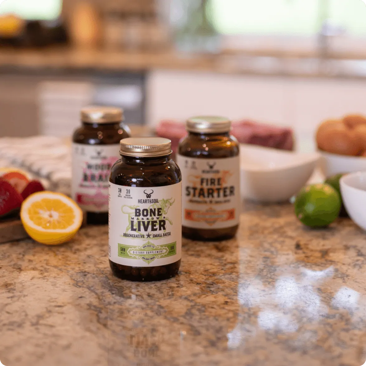 Bone Marrow & Liver, Fire Starter and Mood Brain jars on a kitchen counter with citrus, steak and eggs